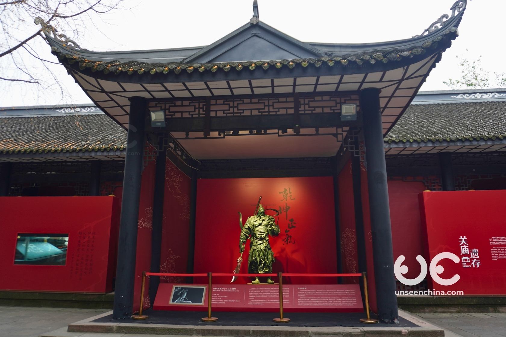 An elegant statue of the warrior Guanyu standing solemnly under a traditional Chinese pavilion at the Wuhou Shrine in Chengdu.