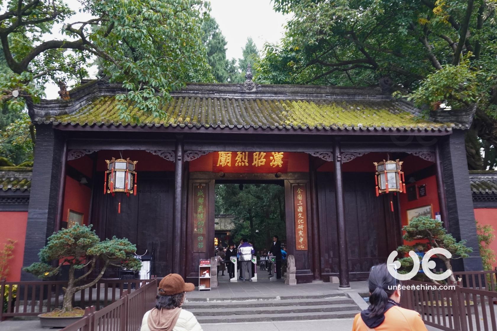 The main traditional entrance gate of the Wuhou Shrine, with Visitors walking toward it.