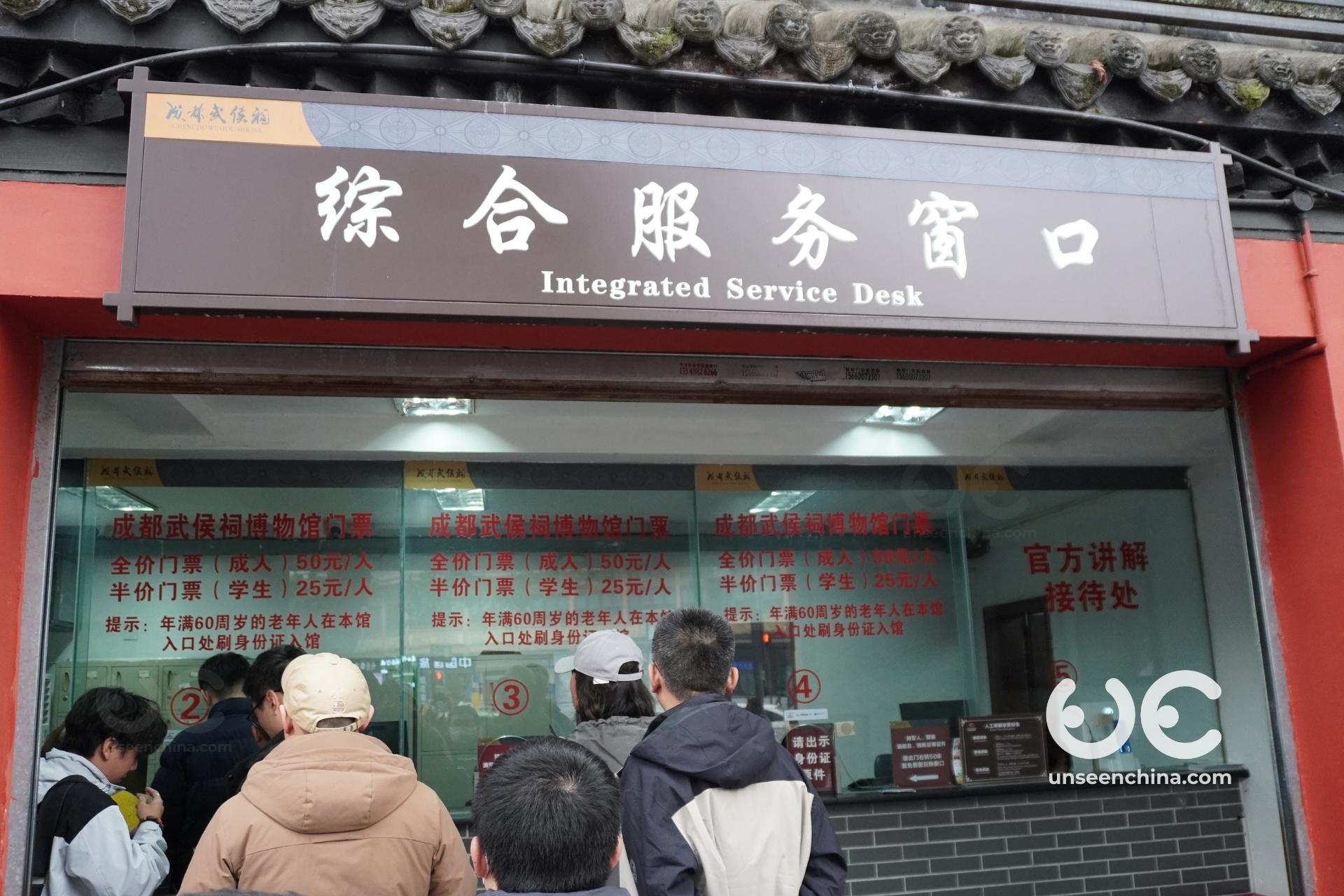 Visitors line up outside the dedicated ticket house, a traditional wooden building at the entrance to Chengdu's Wuhou Shrine.