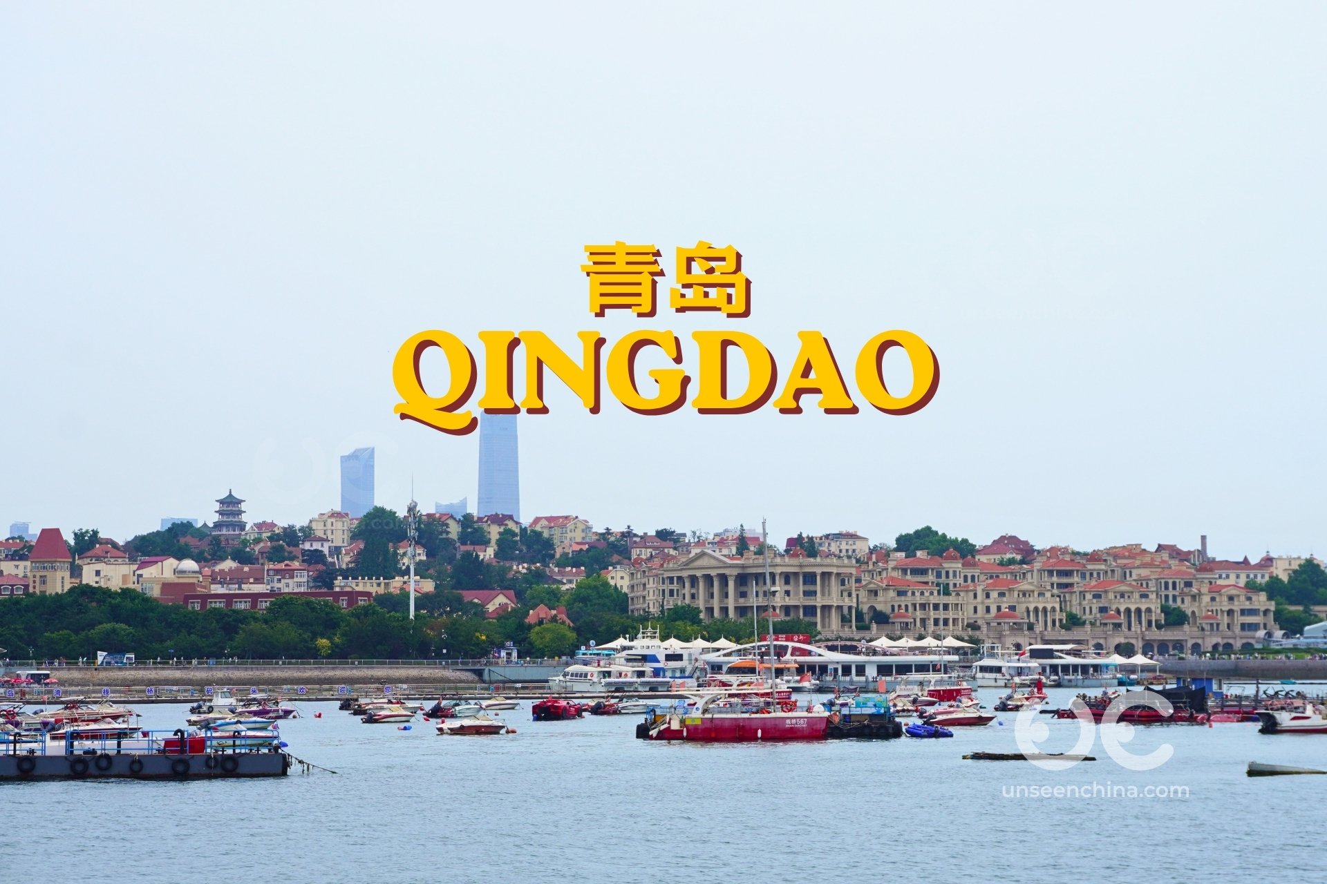 A coastal area in Qingdao with yachts parked along the waterfront, orange-roofed buildings in the background, and yellow text displaying 'Qingdao' in English and Chinese.