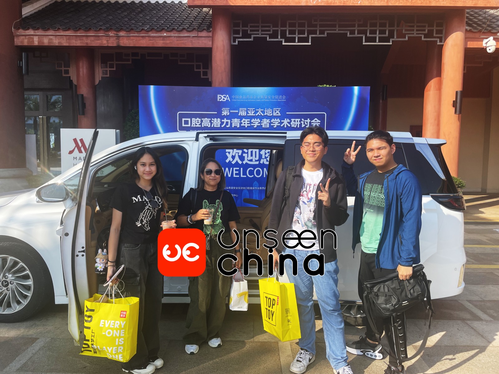Four customers standing in front of our company car, carrying shopping bags.